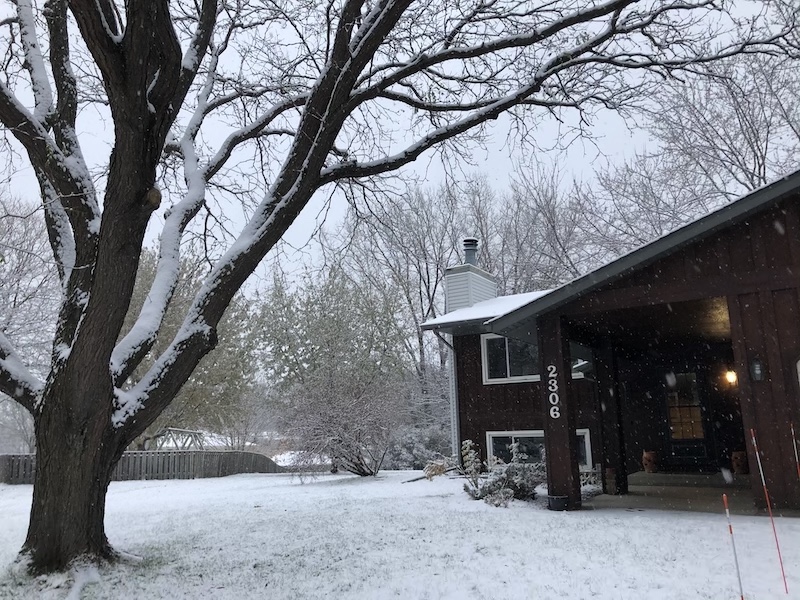 Morning snow falling outside the house